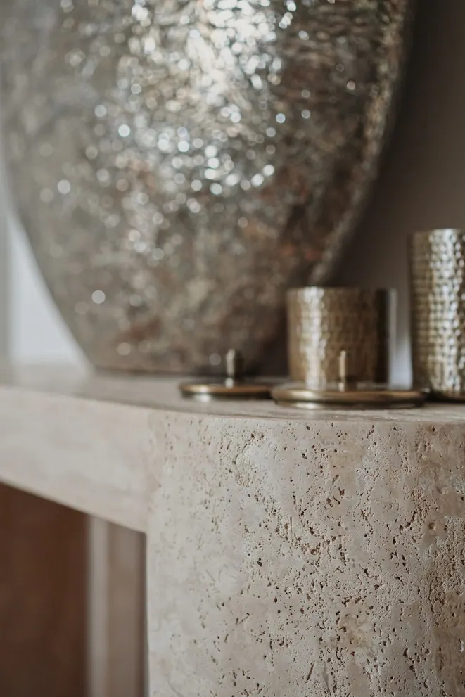 Travertine console with hammered metal vessels