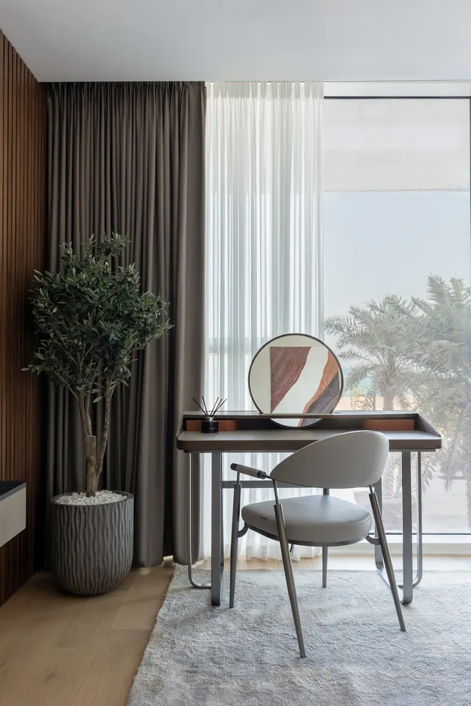 Writing desk by the window with an olive tree and a view of palm trees