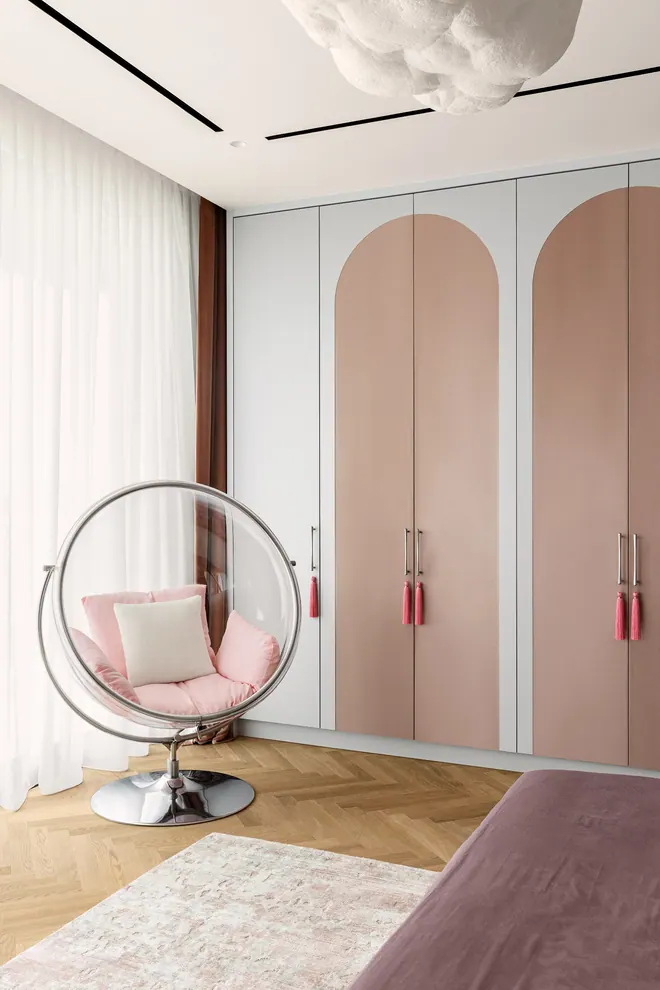Girl's bedroom with built-in wardrobes with pink arched doors and a transparent bubble chair, Palm Jumeirah
