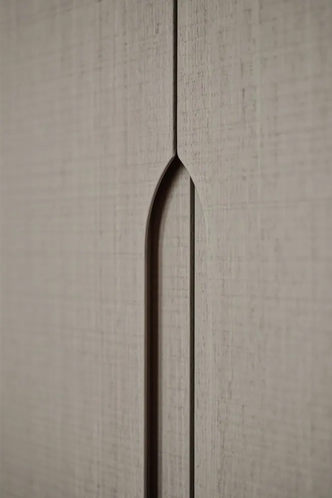 Wardrobe doors in a linen-textured finish with a routed arch-shaped grip