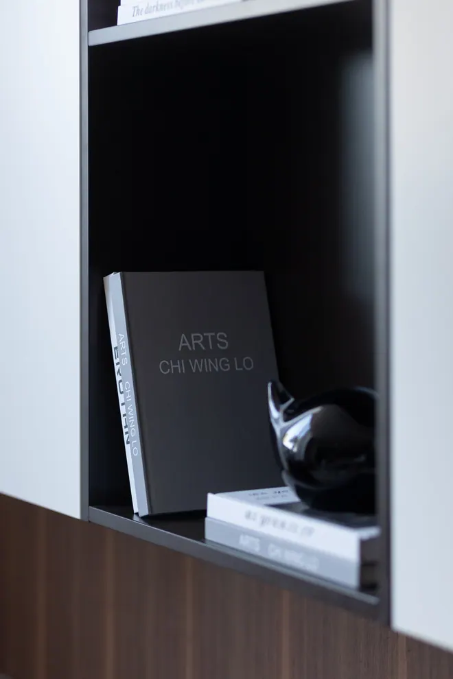 Shelf niche in dark lacquer with art books and a black glass object