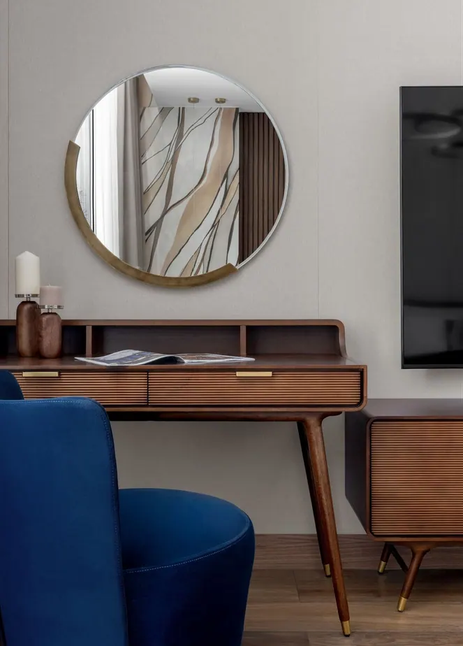 Ribbed walnut dressing table with a round brass-edged mirror and a blue velvet chair